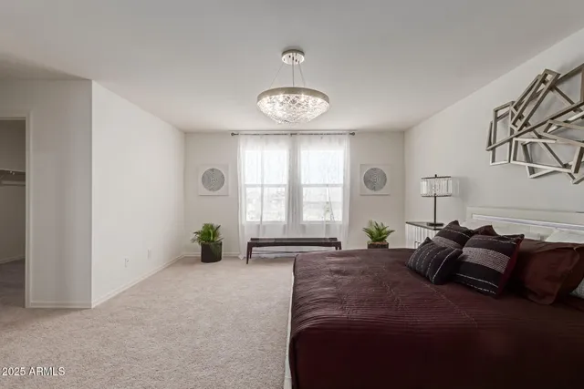 a bedroom with a large bed and a potted plant