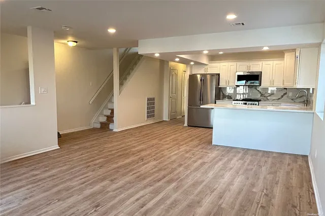 a kitchen with stainless steel appliances granite countertop a refrigerator and a stove top oven