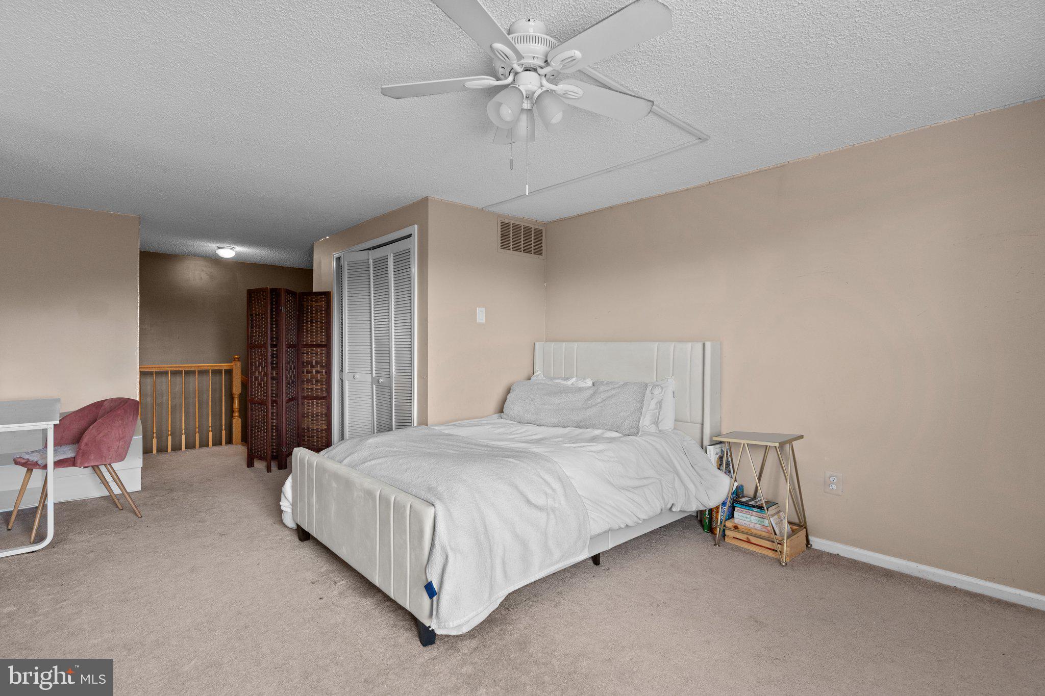 2404 Brookhaven Drive, Unit 330 Yardley, PA 19067 - Photo 19 of 27 a bedroom with a bed and a chandelier