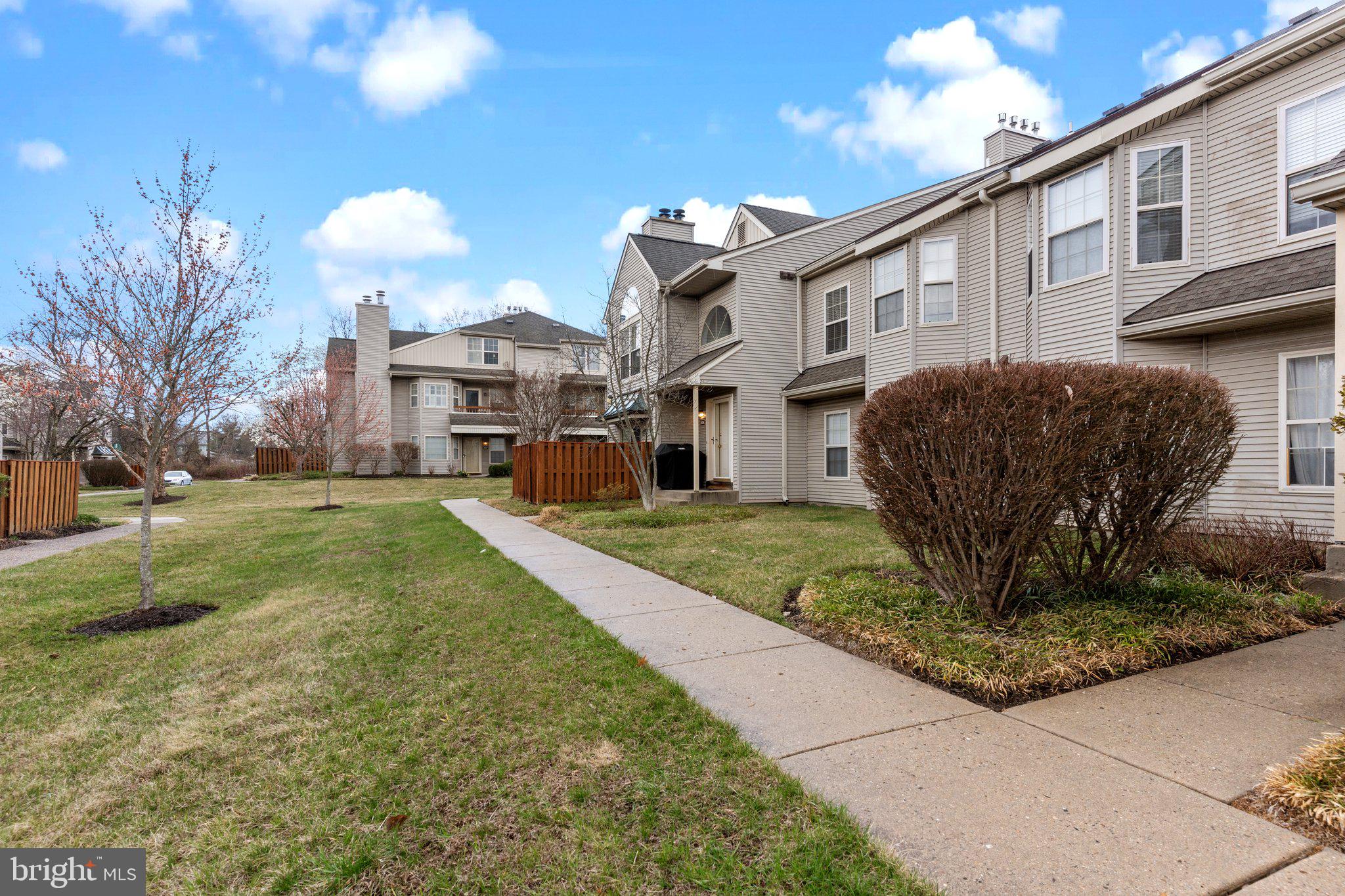 2404 Brookhaven Drive, Unit 330 Yardley, PA 19067 - Photo 26 of 27 a view of a white house with a yard and plants
