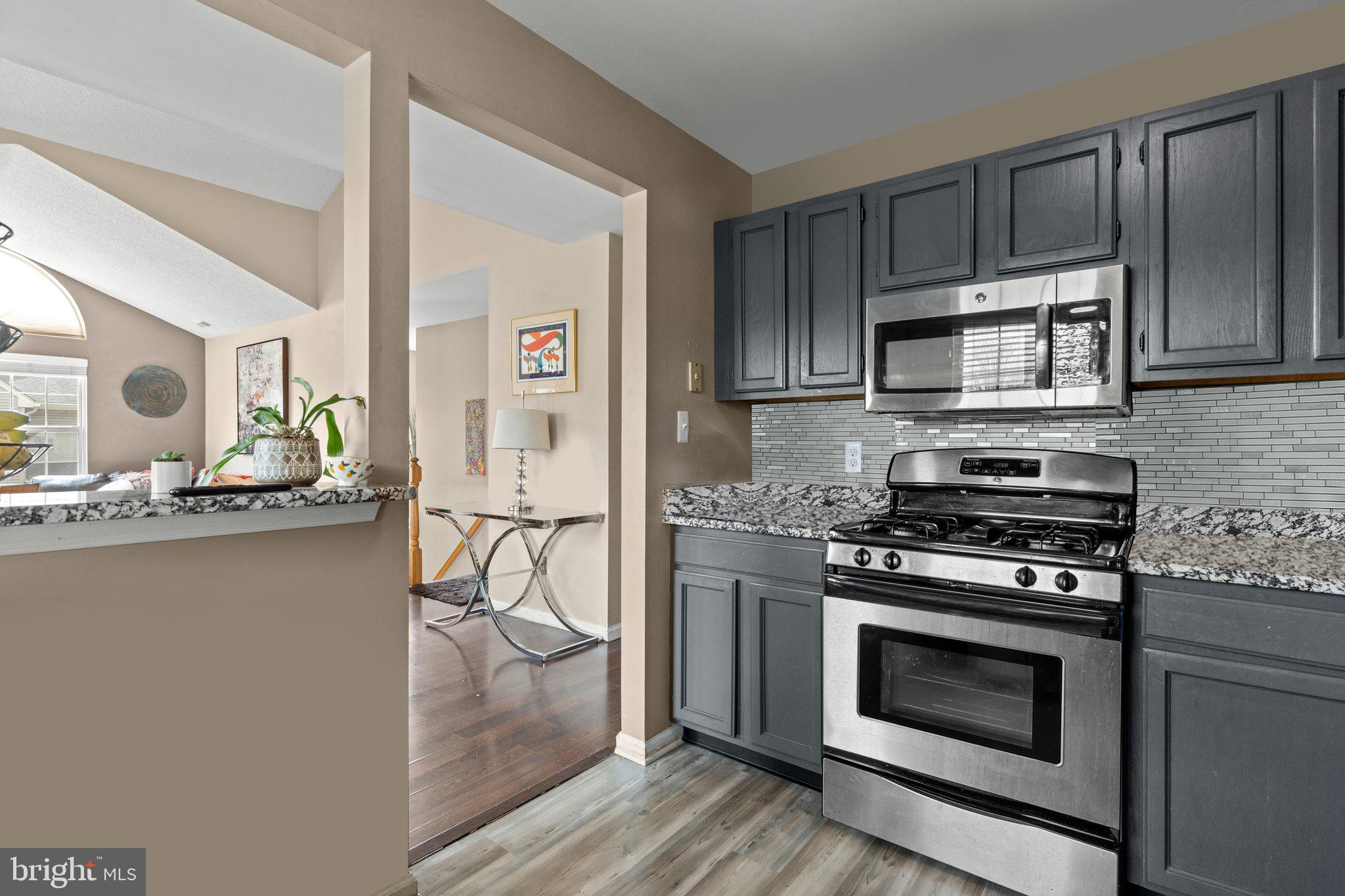 2404 Brookhaven Drive, Unit 330 Yardley, PA 19067 - Photo 8 of 27 a kitchen with granite countertop a stove and a microwave