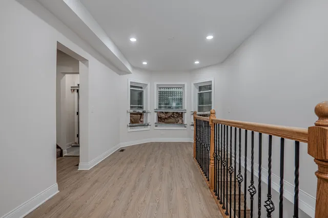 a view of a hallway with wooden floor and livingroom with furniture