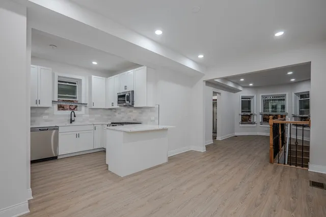 a kitchen with granite countertop white cabinets and stainless steel appliances