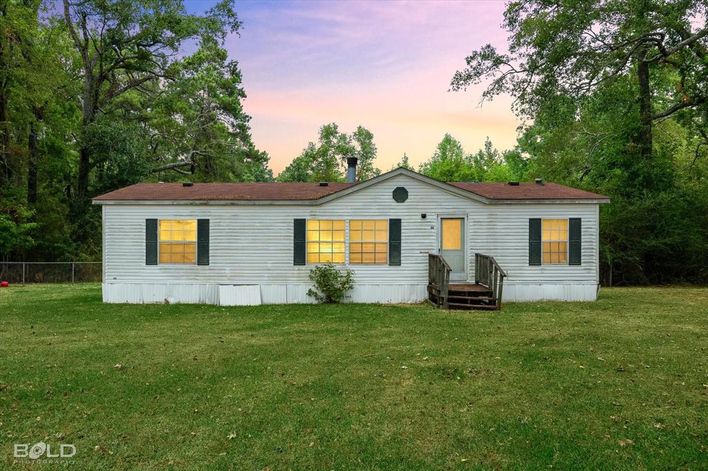 9720 Osburn Road Shreveport, LA 71129 - Photo 1 of 30 Single-story residence featuring light-colored siding, dark shutters, and a wooden entry porch