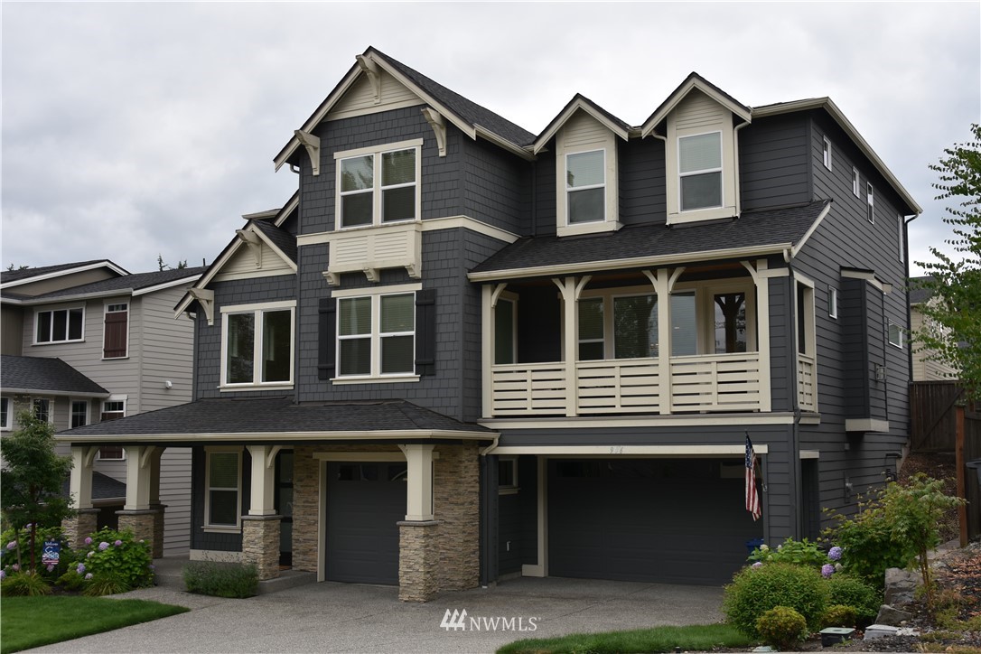 a front view of a house with yard and parking