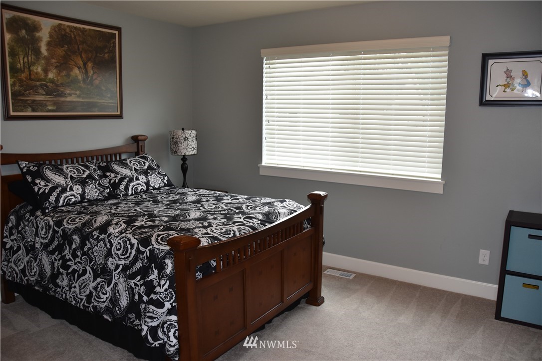 906 231st Street Southeast Bothell, WA 98021 - Photo 12 of 15 a bed sitting in a bedroom next to a window