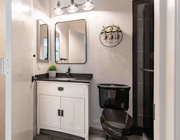 a bathroom with a toilet a sink and mirror
