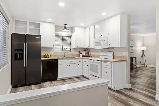 a kitchen with a refrigerator and white cabinets
