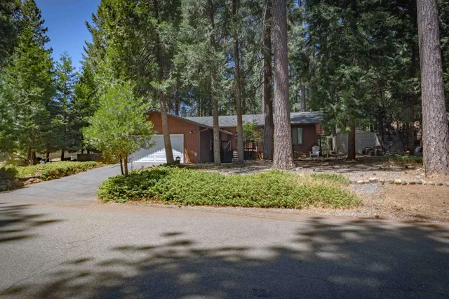 a front view of a house with a yard and potted plants