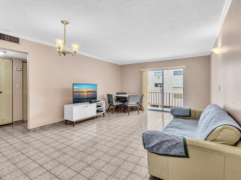1075 West 68th Street, Unit 203 Hialeah, FL 33014 - Photo 11 of 41 a living room with furniture and a flat screen tv