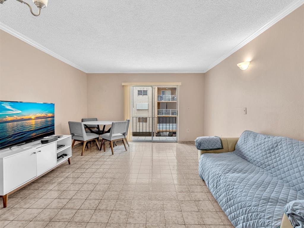 1075 West 68th Street, Unit 203 Hialeah, FL 33014 - Photo 12 of 41 a living room with furniture and a flat screen tv