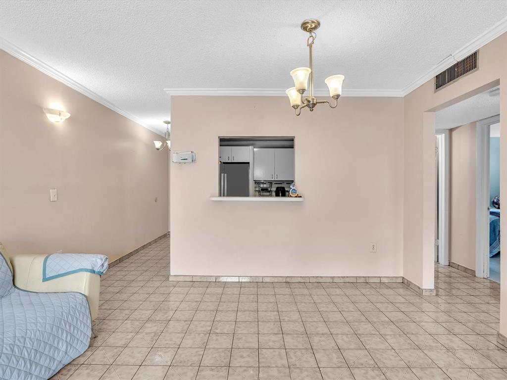 1075 West 68th Street, Unit 203 Hialeah, FL 33014 - Photo 15 of 41 a view of a hallway with a chandelier