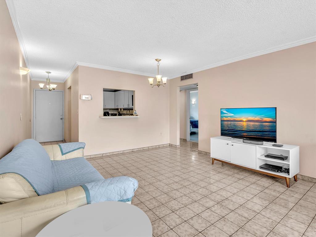 1075 West 68th Street, Unit 203 Hialeah, FL 33014 - Photo 16 of 41 a living room with furniture and a flat screen tv