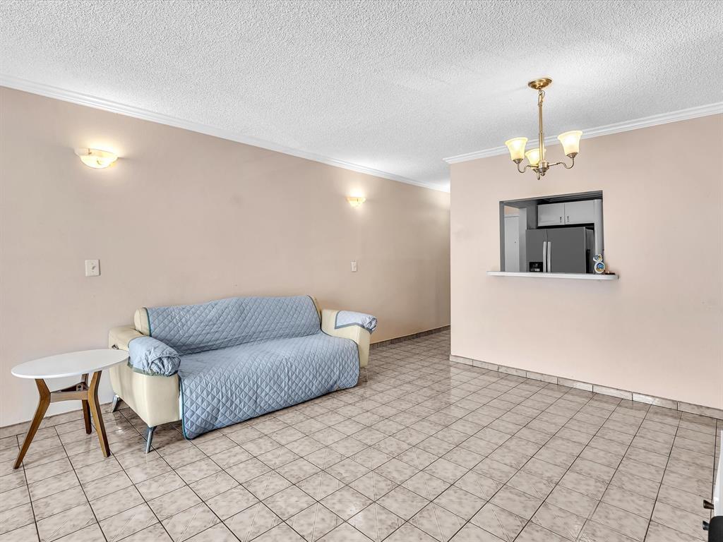 1075 West 68th Street, Unit 203 Hialeah, FL 33014 - Photo 17 of 41 a living room with furniture and a chandelier