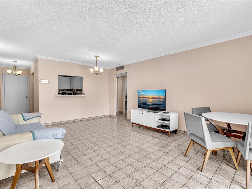 1075 West 68th Street, Unit 203 Hialeah, FL 33014 - Photo 19 of 41 a living room with furniture and a flat screen tv