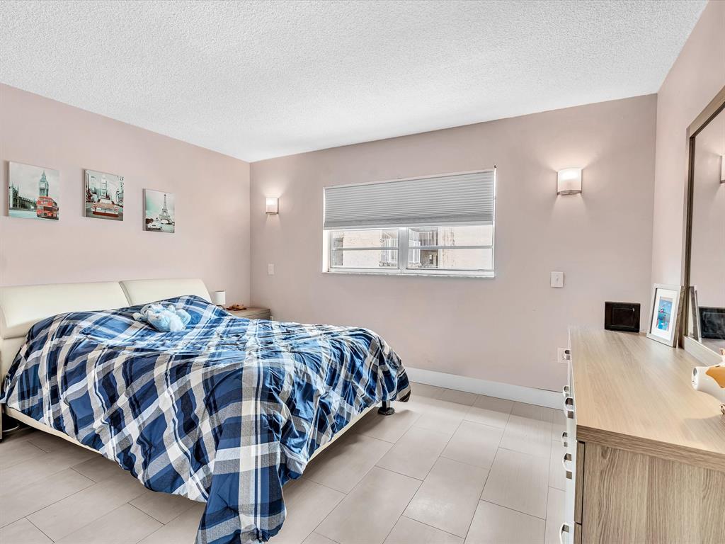 1075 West 68th Street, Unit 203 Hialeah, FL 33014 - Photo 26 of 41 a bedroom with a bed and a table in it