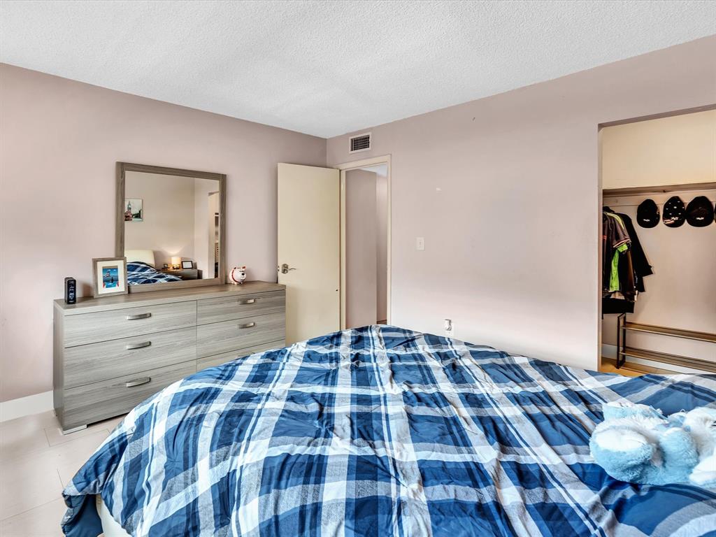 1075 West 68th Street, Unit 203 Hialeah, FL 33014 - Photo 27 of 41 a bedroom with a bed and a mirror