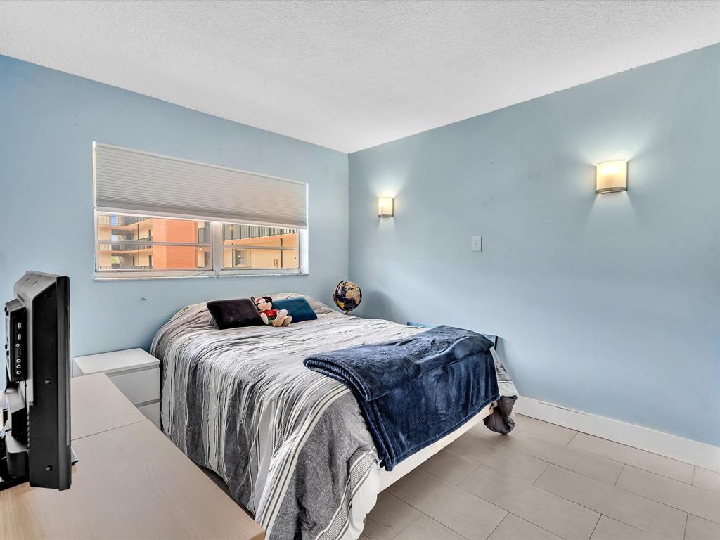 1075 West 68th Street, Unit 203 Hialeah, FL 33014 - Photo 29 of 41 a bedroom with a bed and a window