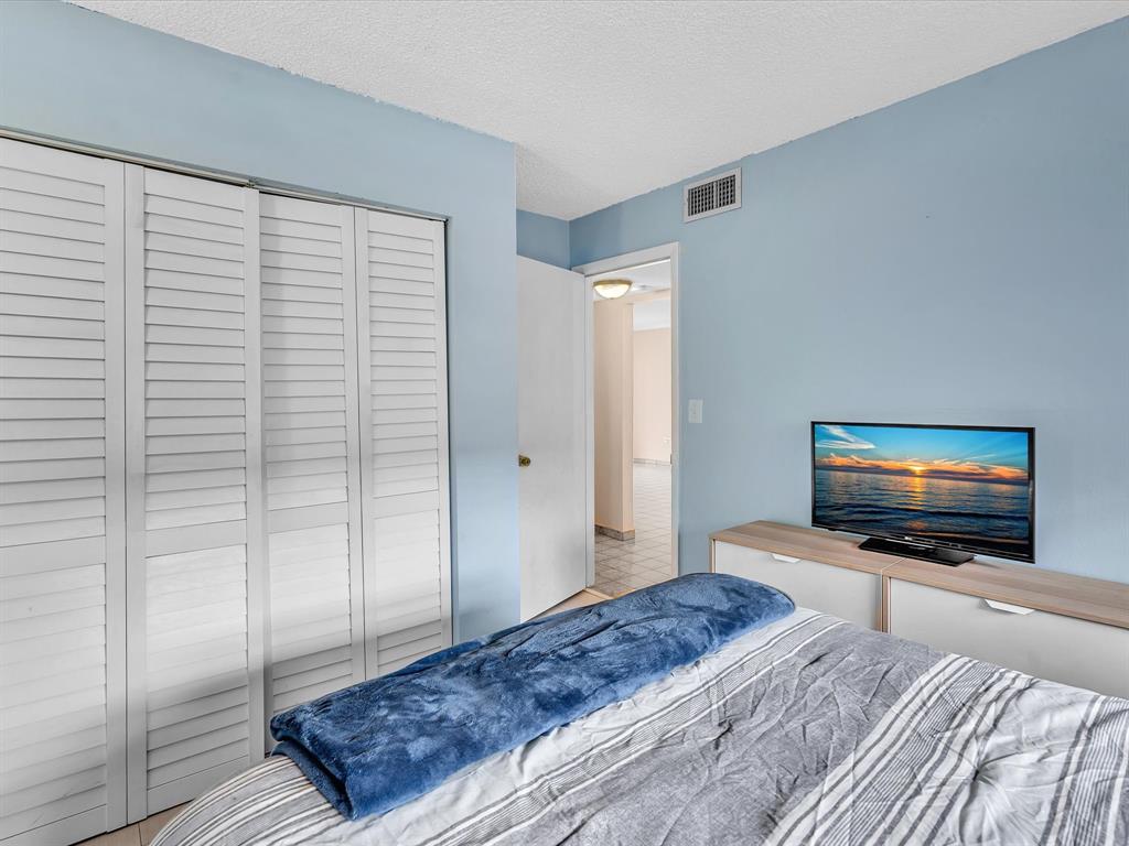 1075 West 68th Street, Unit 203 Hialeah, FL 33014 - Photo 30 of 41 a bedroom with a bed and a flat screen tv