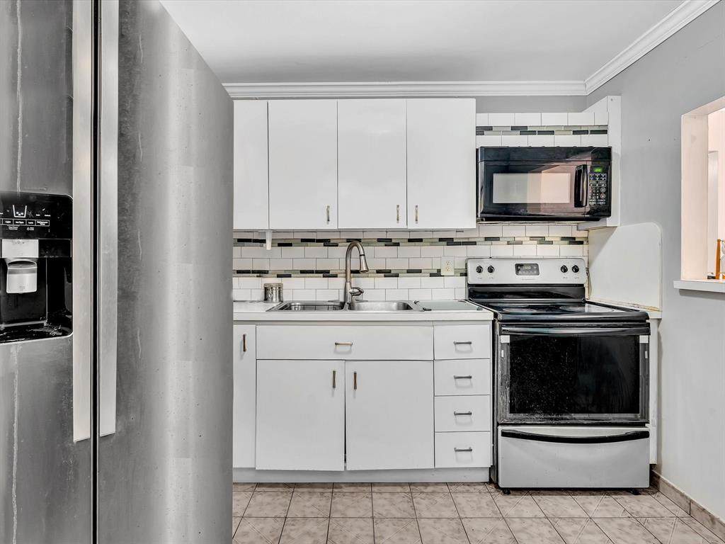 1075 West 68th Street, Unit 203 Hialeah, FL 33014 - Photo 6 of 41 a kitchen with white cabinets and stainless steel appliances