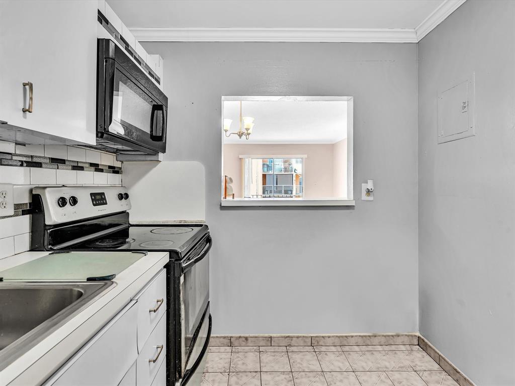 1075 West 68th Street, Unit 203 Hialeah, FL 33014 - Photo 9 of 41 a view of a kitchen with stove and cabinets
