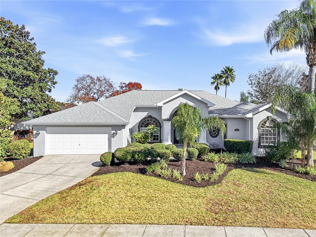 3521 Conifer Loop Spring Hill, FL 34609 - Photo 1 of 71 a view of a white house with a yard potted plants and a large tree