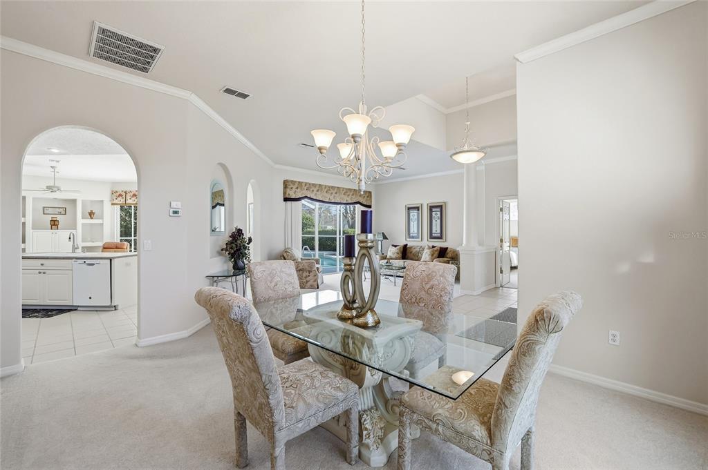 3521 Conifer Loop Spring Hill, FL 34609 - Photo 14 of 71 a dining room with wooden floor a chandelier a wooden table and chairs