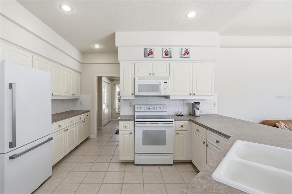 3521 Conifer Loop Spring Hill, FL 34609 - Photo 24 of 71 a kitchen with white cabinets stainless steel appliances and a sink