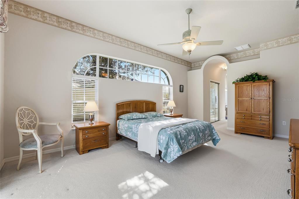 3521 Conifer Loop Spring Hill, FL 34609 - Photo 33 of 71 a spacious bedroom with a bed a couch and dresser