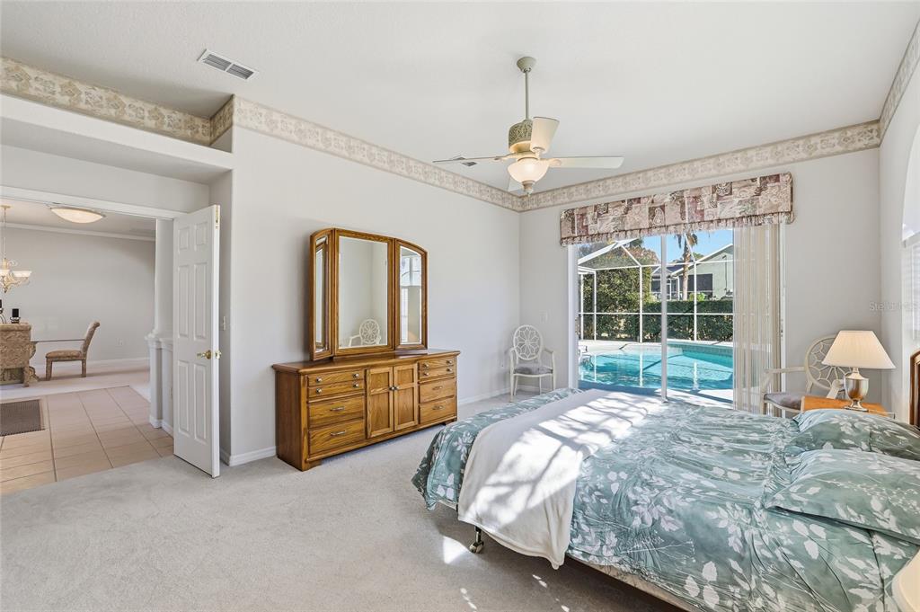 3521 Conifer Loop Spring Hill, FL 34609 - Photo 35 of 71 a spacious bedroom with a bed and dresser with wooden floor