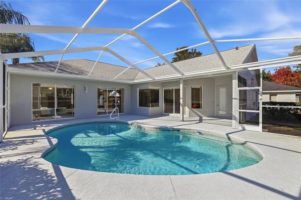 3521 Conifer Loop Spring Hill, FL 34609 - Photo 50 of 71 a view of a backyard with table and chairs under an umbrella