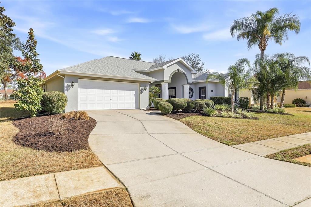 3521 Conifer Loop Spring Hill, FL 34609 - Photo 5 of 71 a front view of a house with a yard and garage