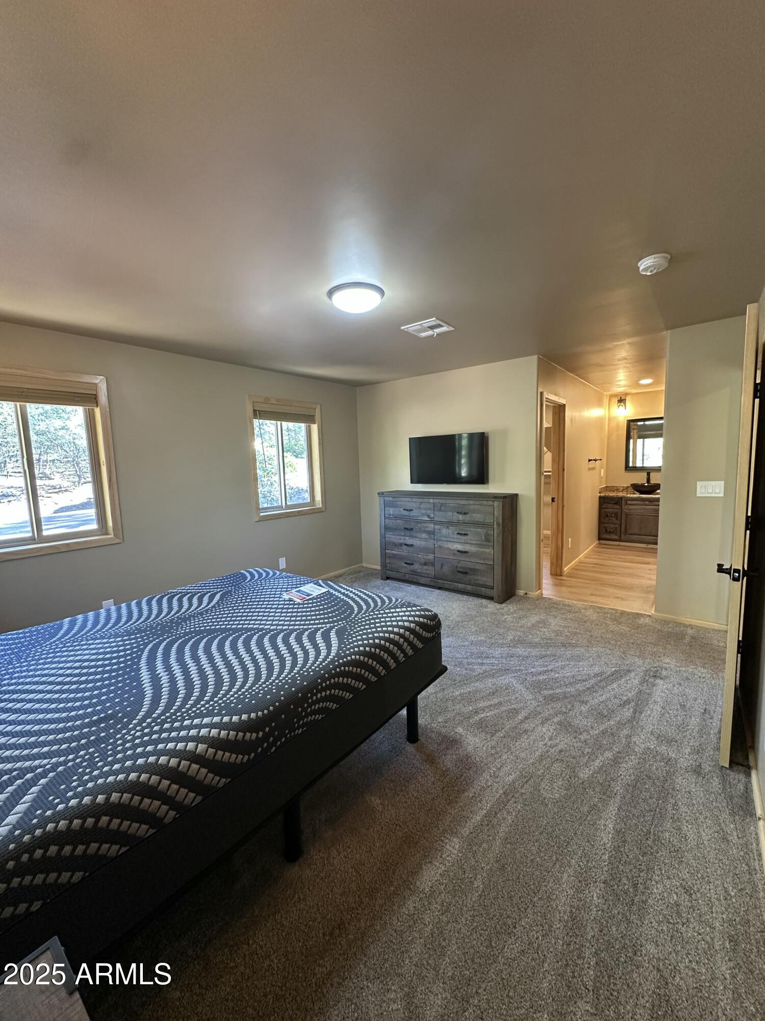 3457 Whispering Pines Road Pine, AZ 85544 - Photo 17 of 27 a spacious bedroom with a bed and a couch