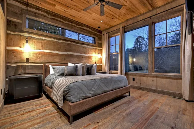 a bedroom with a bed a flat screen tv and a fireplace