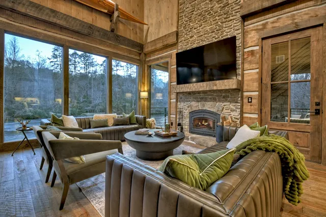 a view of a dining room with furniture a chandelier and large windows