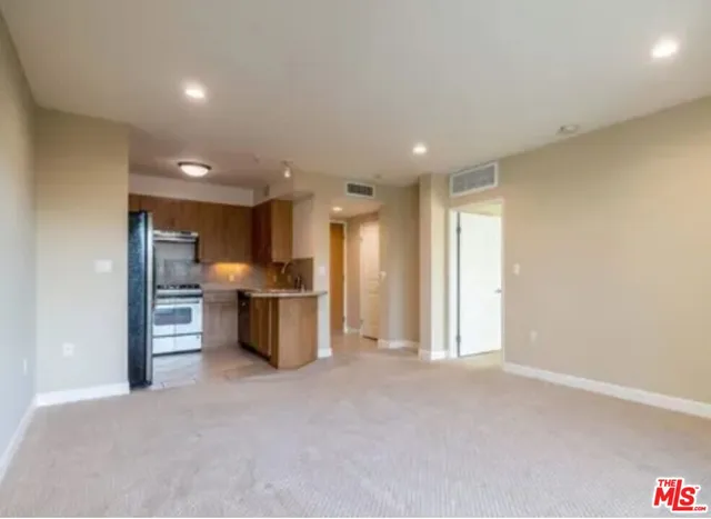 a view of a kitchen with refrigerator and chairs