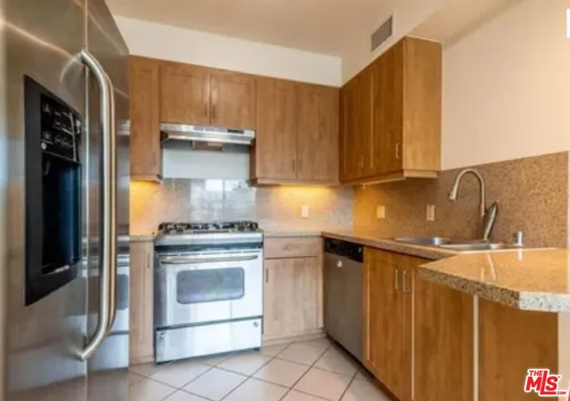 a kitchen with stainless steel appliances granite countertop a stove and a refrigerator