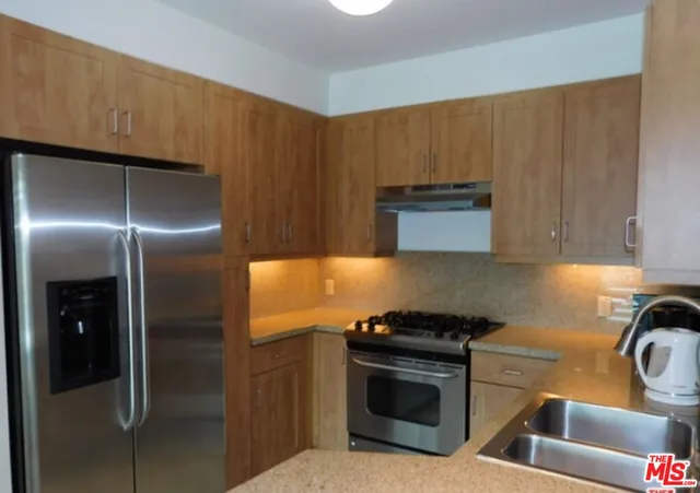 a kitchen with a refrigerator and a stove top oven