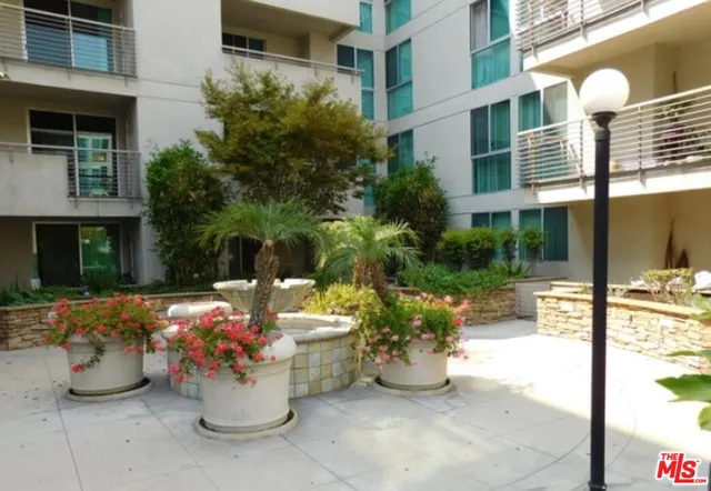 a view of a patio with dining table and chairs and potted plants