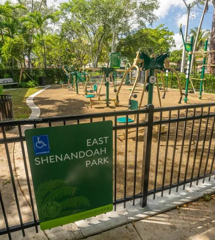 a view of a brick house next to a yard with large trees