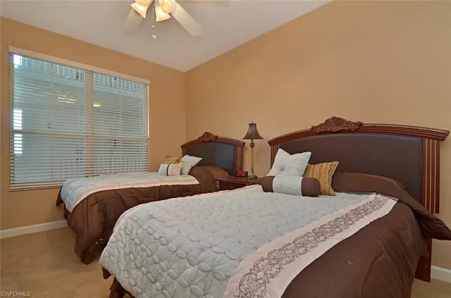 a bedroom with two beds and a chandelier