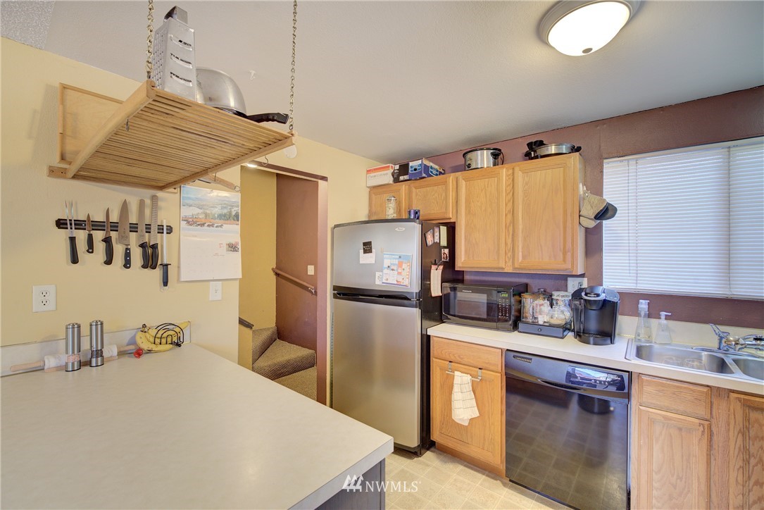 126 Pelly Avenue North, Unit AB Renton, WA 98057 - Photo 6 of 23 a kitchen with a sink a refrigerator and cabinets