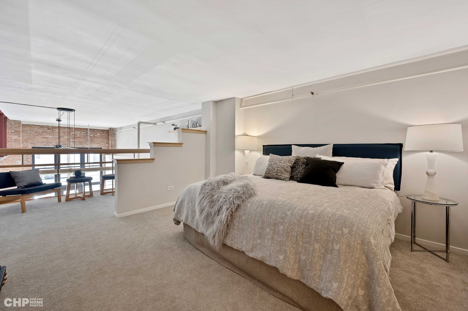 203 South Sangamon Street, Unit 206 Chicago, IL 60607 - Photo 9 of 20 a spacious bedroom with a bed and a table in it