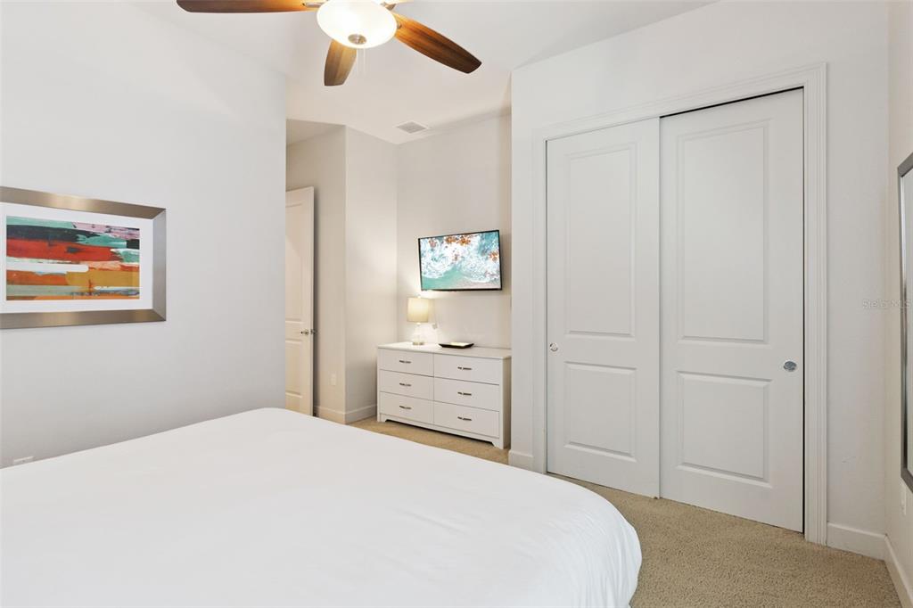 7423 Sparkling Court Reunion, FL 34747 - Photo 30 of 62 a bedroom with a bed and a chandelier