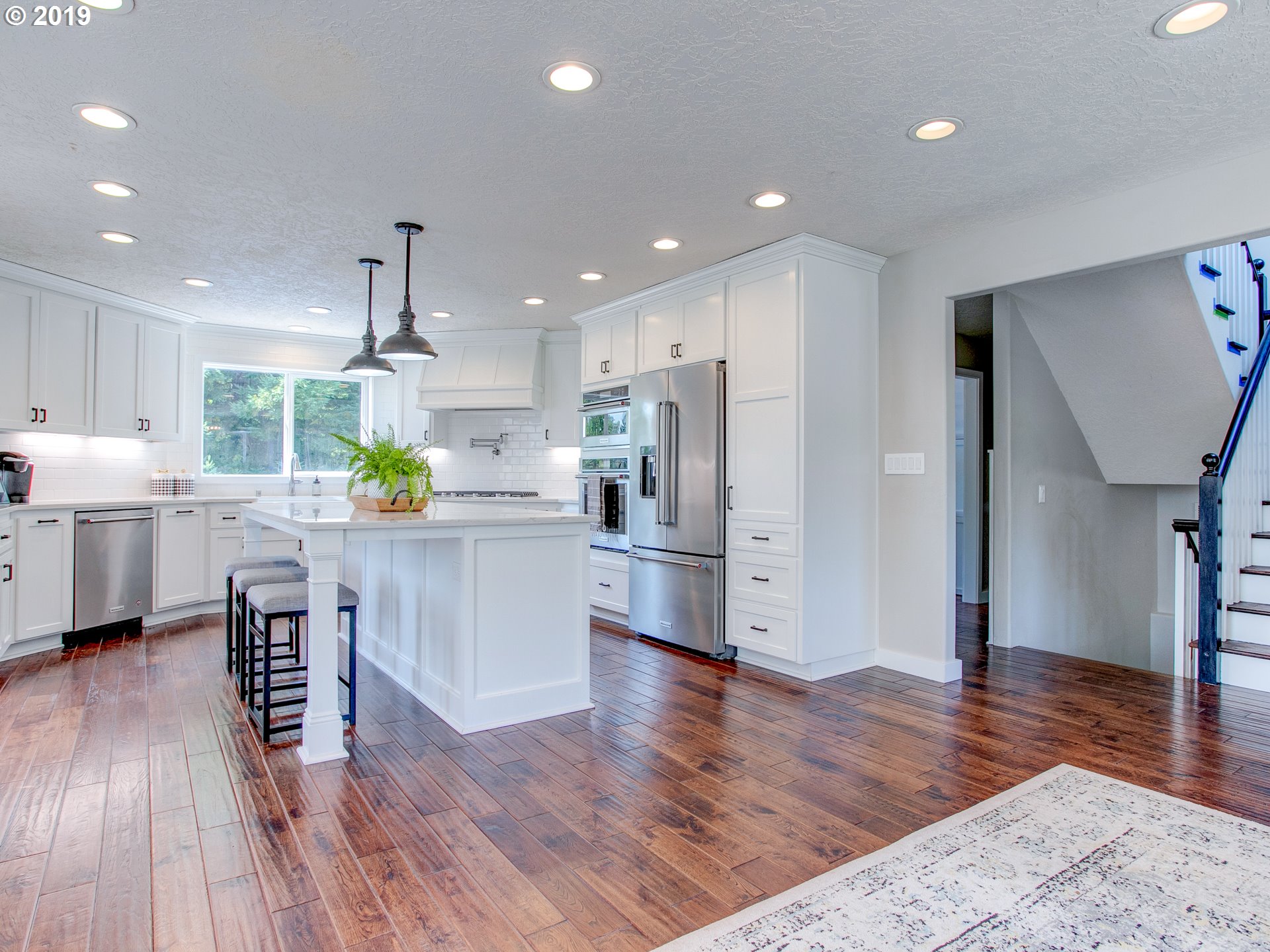 417 Northeast 299th Street Ridgefield, WA 98642 - Photo 16 of 32 a kitchen with stainless steel appliances kitchen island wooden floors wooden cabinets and center island