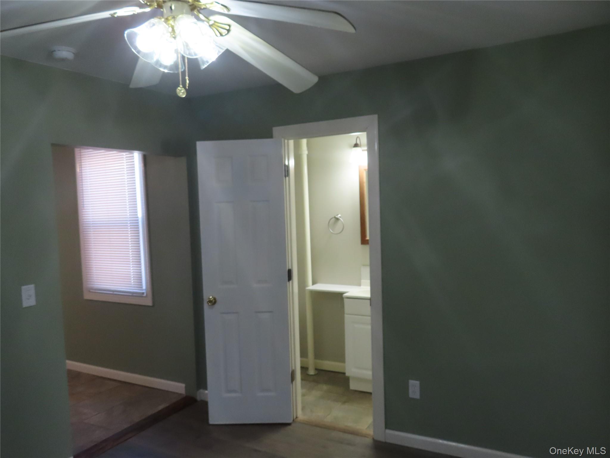 44 Terry Street Patchogue, NY 11772 - Photo 15 of 15 an empty room with a window and a chandelier fan