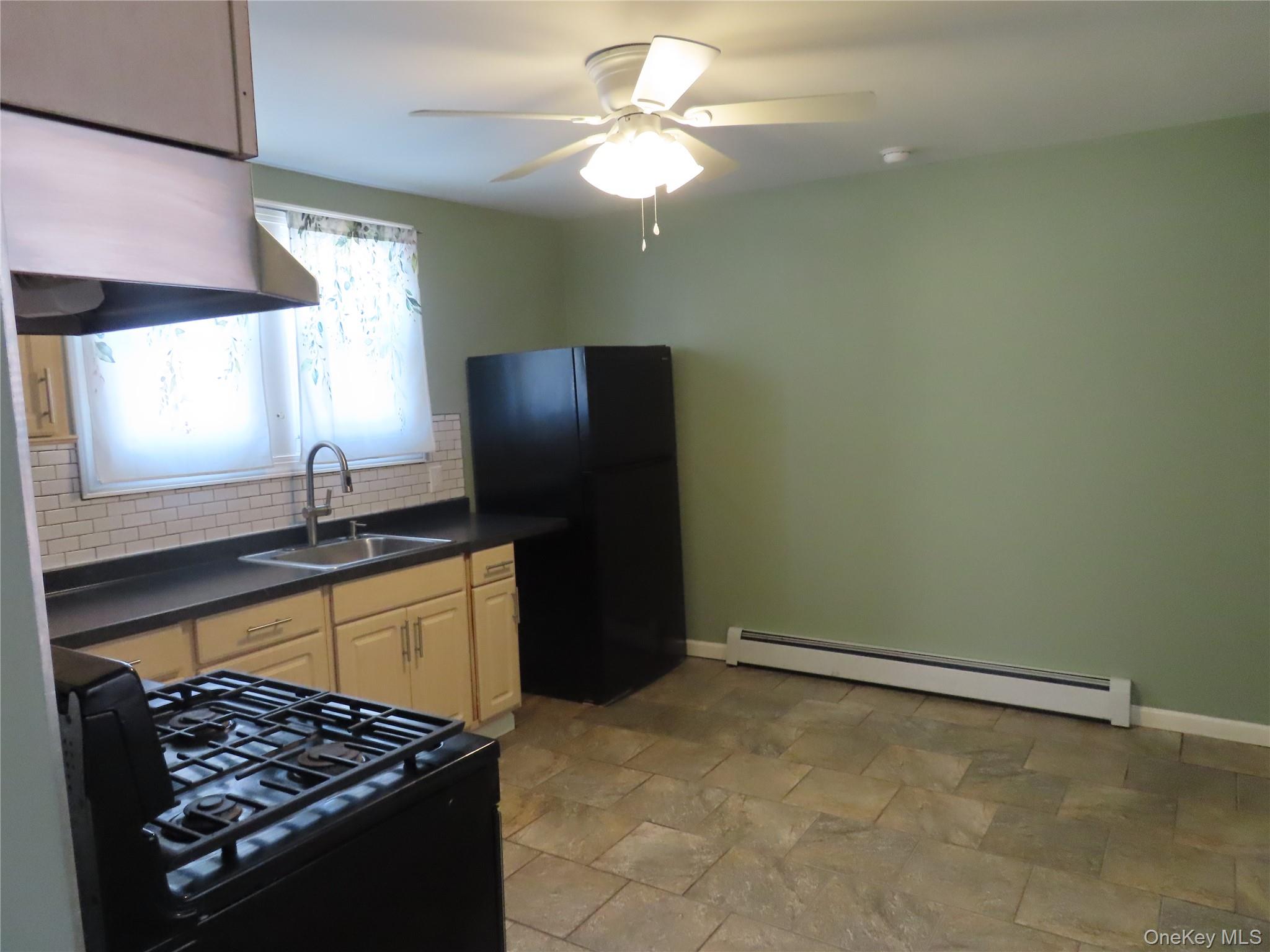 44 Terry Street Patchogue, NY 11772 - Photo 5 of 15 a kitchen with a sink a stove and a refrigerator