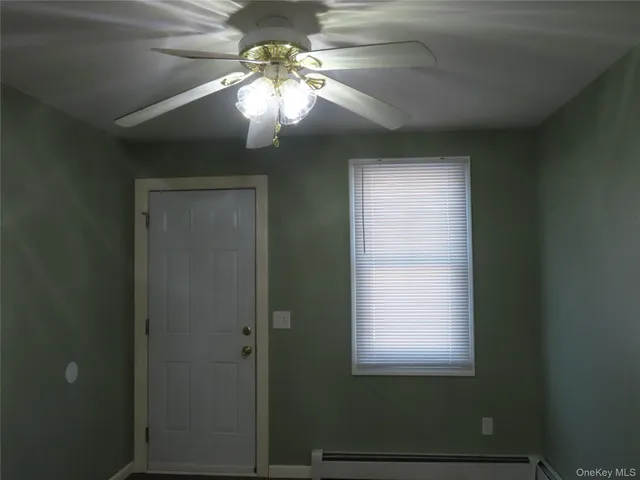 a view of a livingroom with a chandelier fan and a window