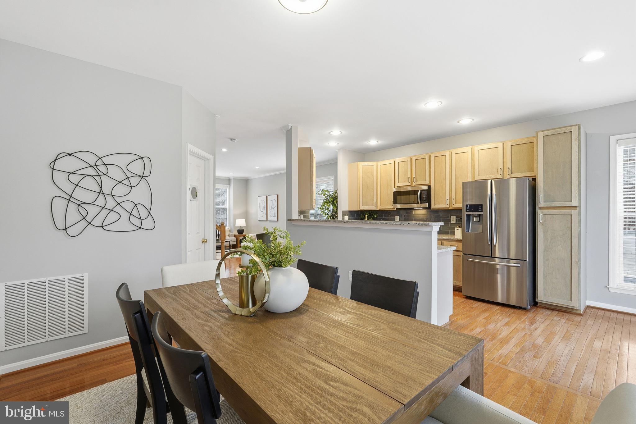46600 Chase View Terrace Sterling, VA 20164 - Photo 11 of 38 a kitchen with a table chairs refrigerator and microwave