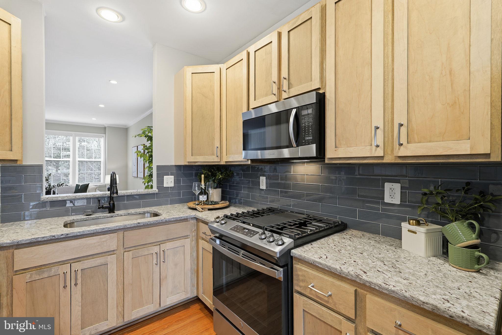 46600 Chase View Terrace Sterling, VA 20164 - Photo 6 of 38 a kitchen with granite countertop a sink a stove and cabinets